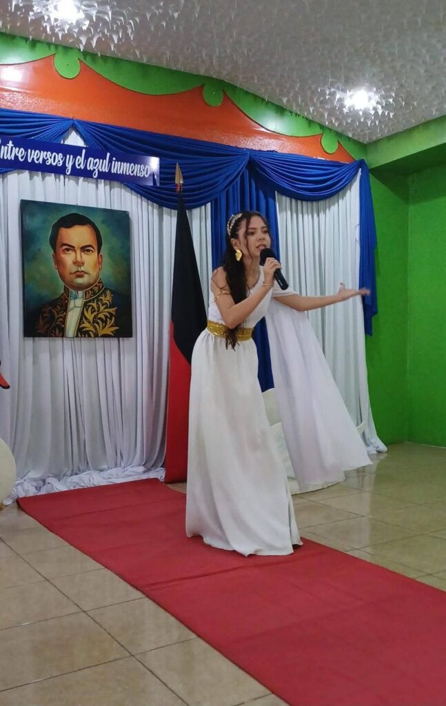 Estudiante participando en acto cultural sobre el escenario del colegio